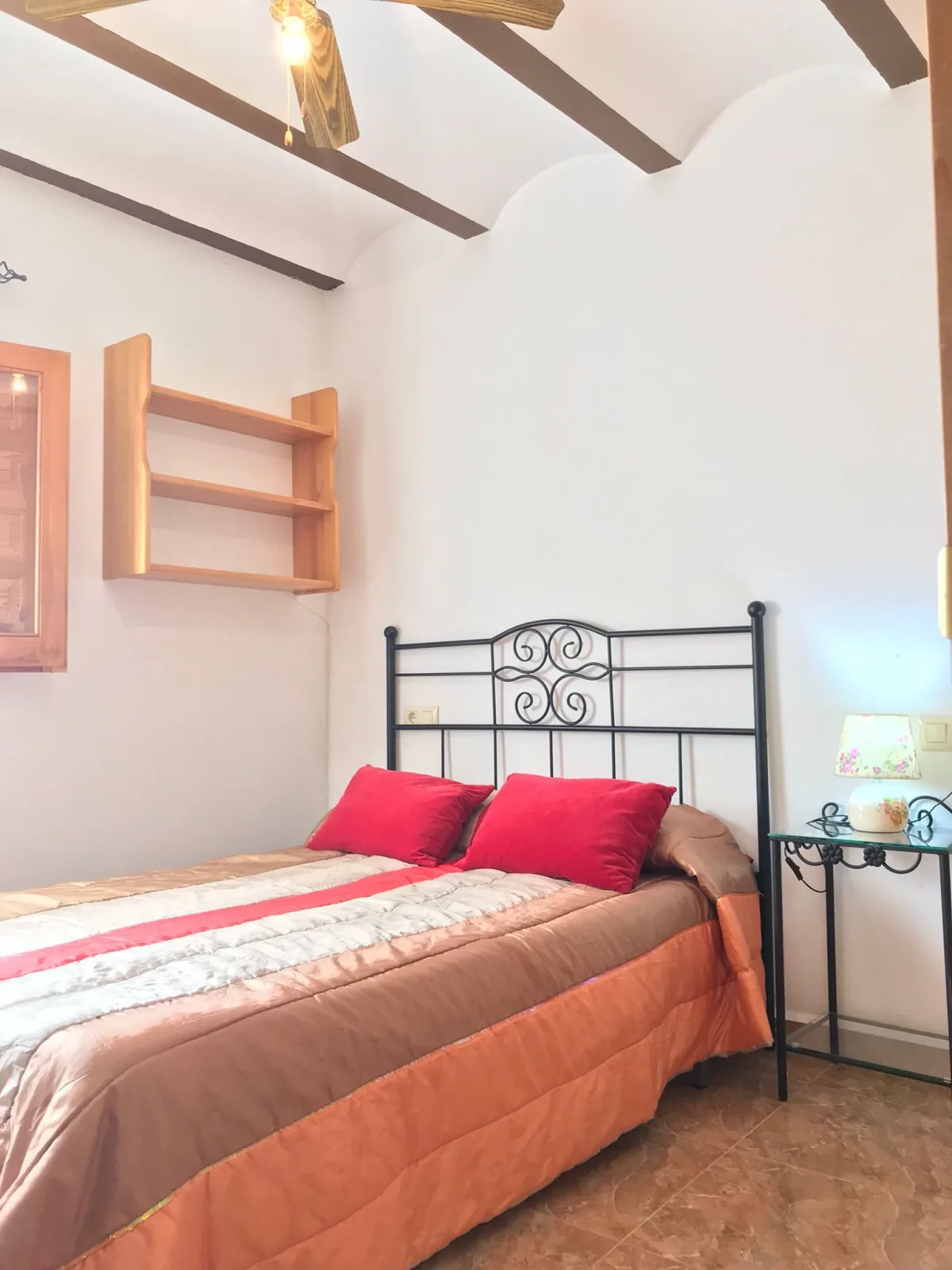 Helles Schlafzimmer mit Fenster und grünem Fensterladen
